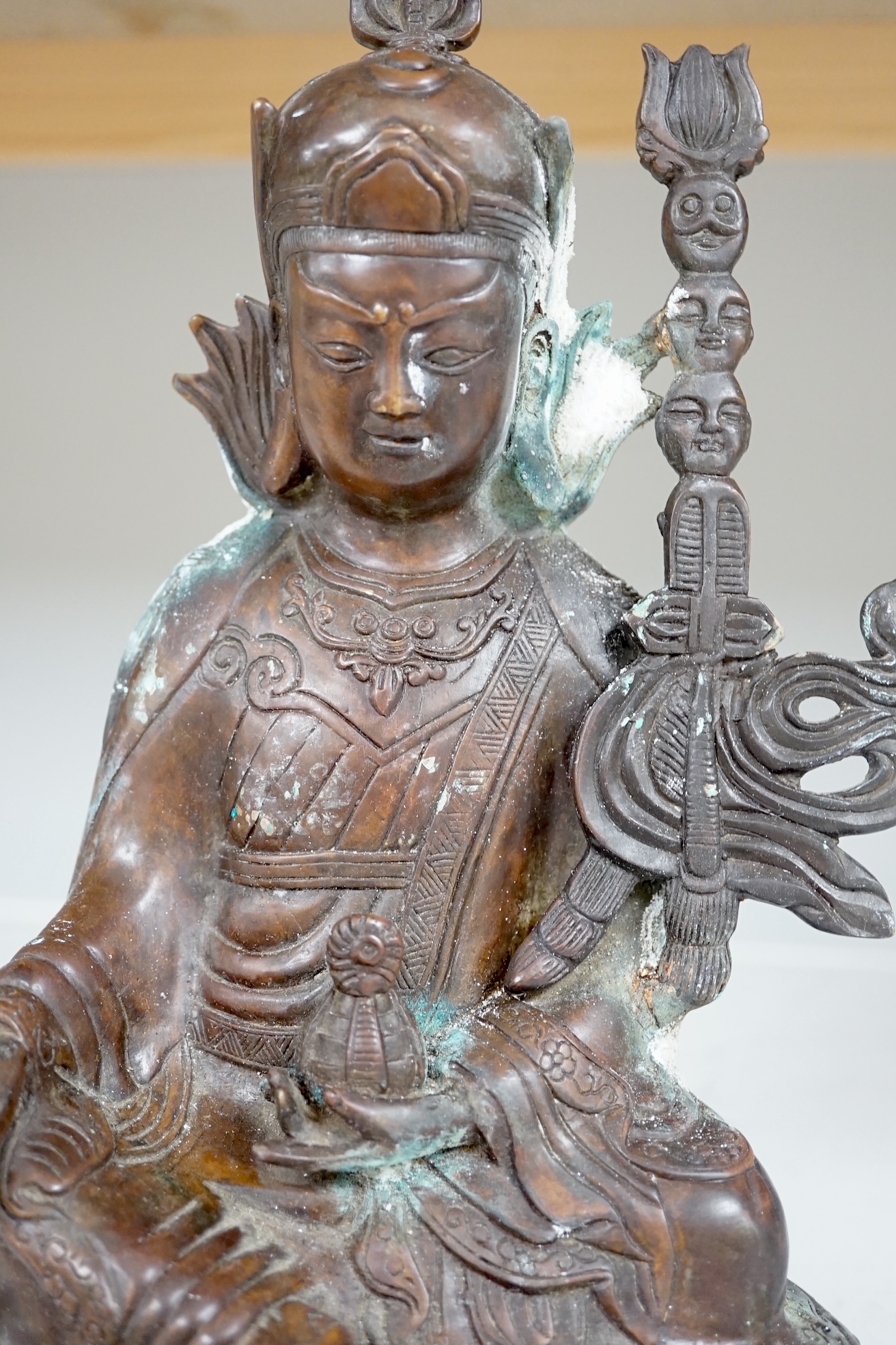 A Tibetan bronze Padmasambhava Buddhist figure, 29.5cm high. Condition - poor to fair.